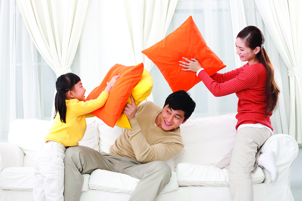 Beijing, China --- Family doing pillow fighting --- Image by © Lane Oatey/Blue Jean Images/Corbis